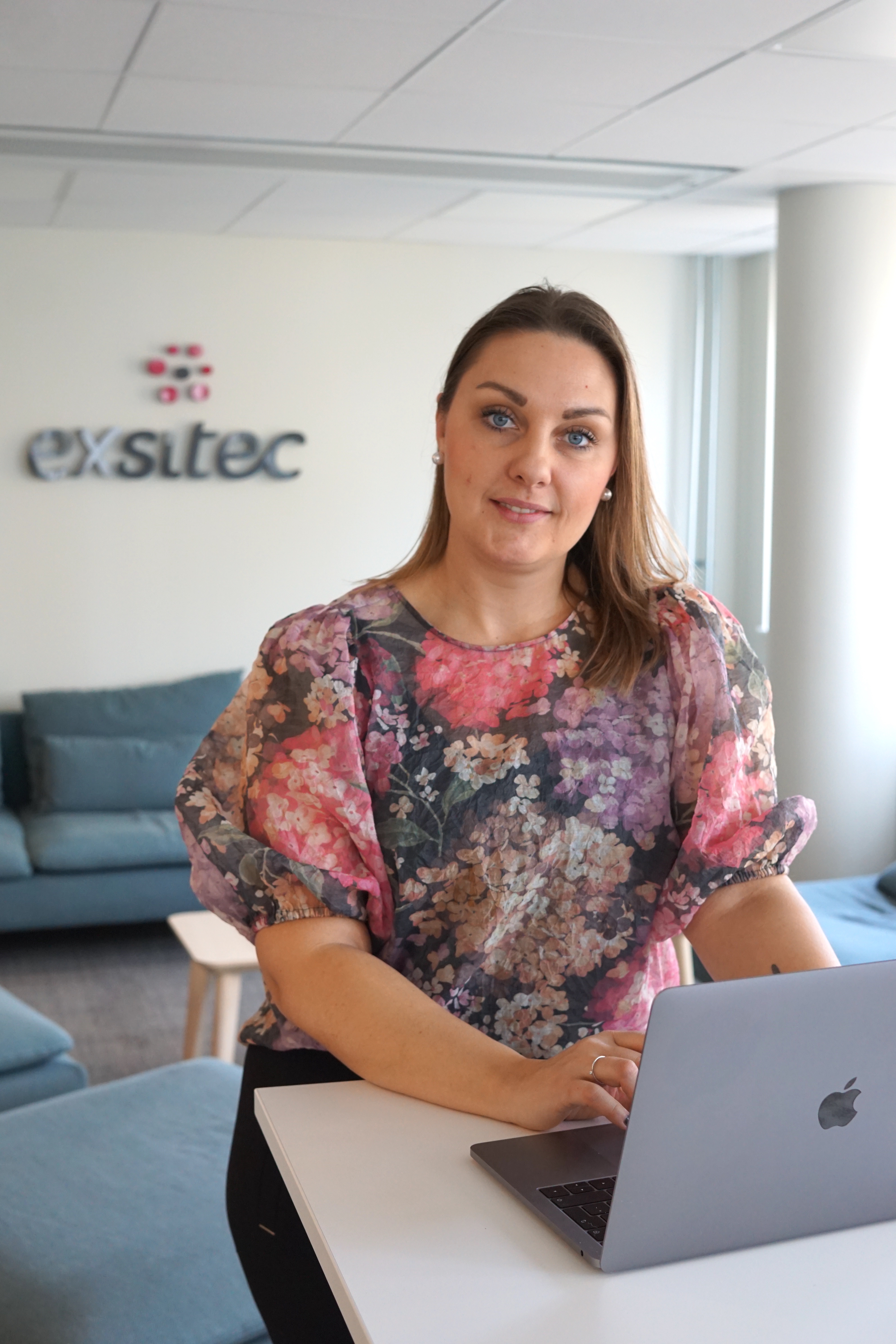 pernilla chis working on her laptop at the office at exsitec